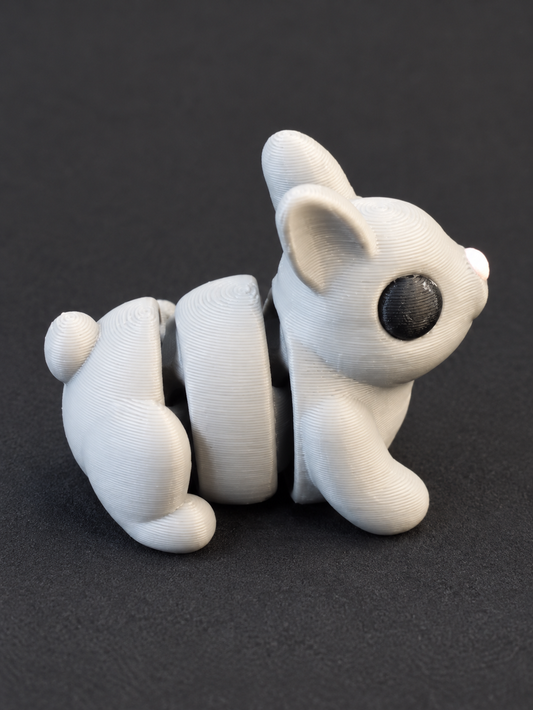 White articulated 3D-printed bunny with upright ears, curled tail, and black eye