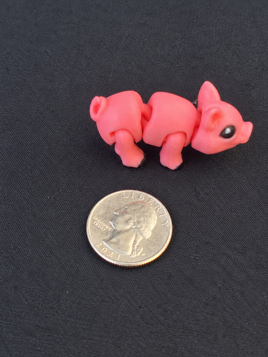 Pink articulated 3D printed pig mini beside a quarter for scale