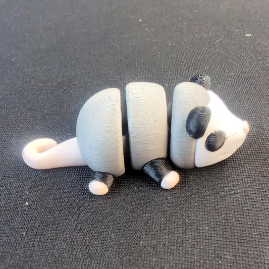 Articulated black-and-white possum with a curled tail
