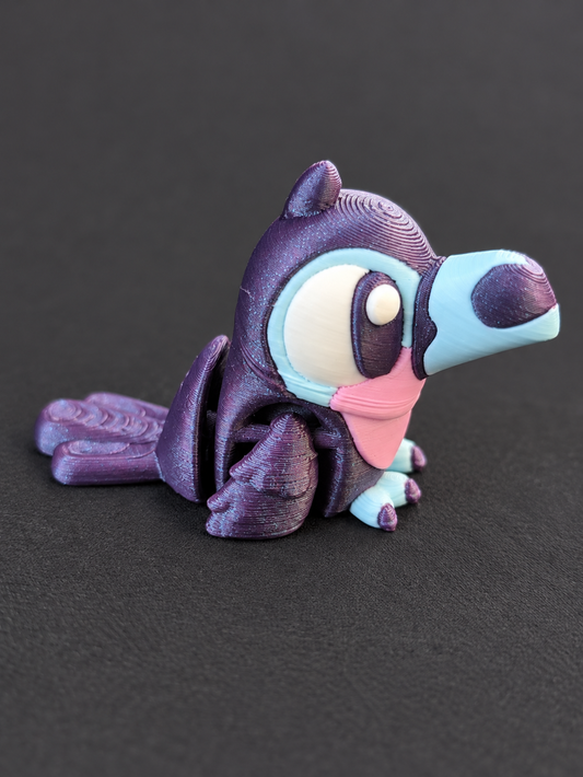Articulated 3D-printed toucan in purple, blue, pink, and white