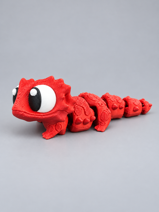 Red articulated 3D-printed bearded dragon with spiky head and segmented tail