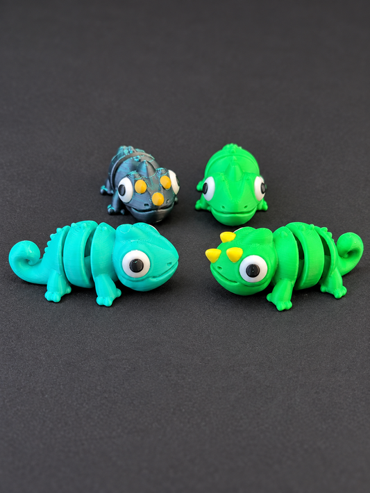 Four 3D-printed articulated chameleons, showing horned and hornless styles