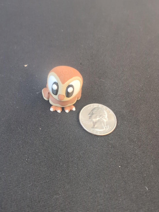 Brown and cream owl mini beside a quarter for scale