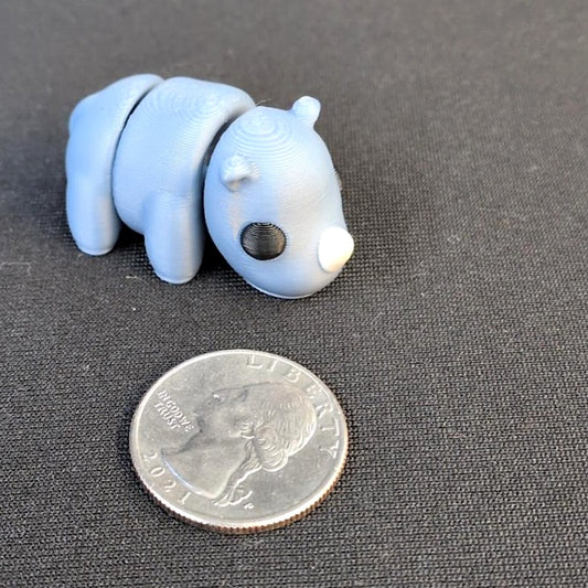 Light blue articulated 3D printed Rhino beside a quarter for scale