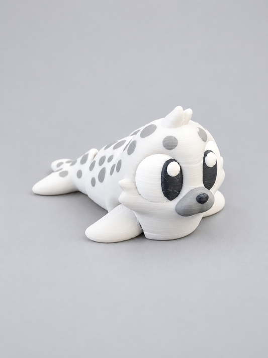 White and gray spotted 3D-printed seal figure with flippers and spotted back
