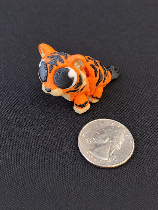 Small orange and black striped 3D printed tiger mini with quarter for scale