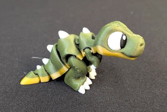 Olive green and yellow articulated T-rex Mini with white spikes and claws